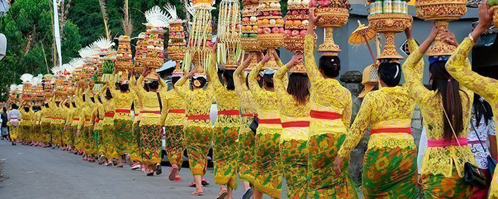 Procession af smukke balinesiske kvinder i traditionelle kostumer, på vej til hinduistisk ceremoni på Bali.