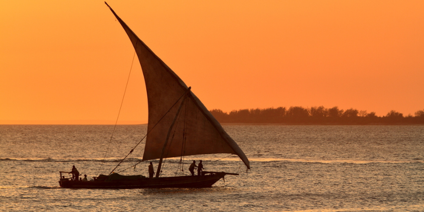 Traditionel dhow-sejlbåd ved solnedgang i Zanzibar, Tanzania