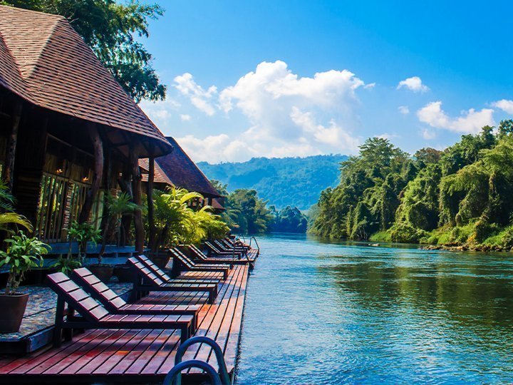 Loungestole omgivet af frodigt grønt ved Kwai-floden.